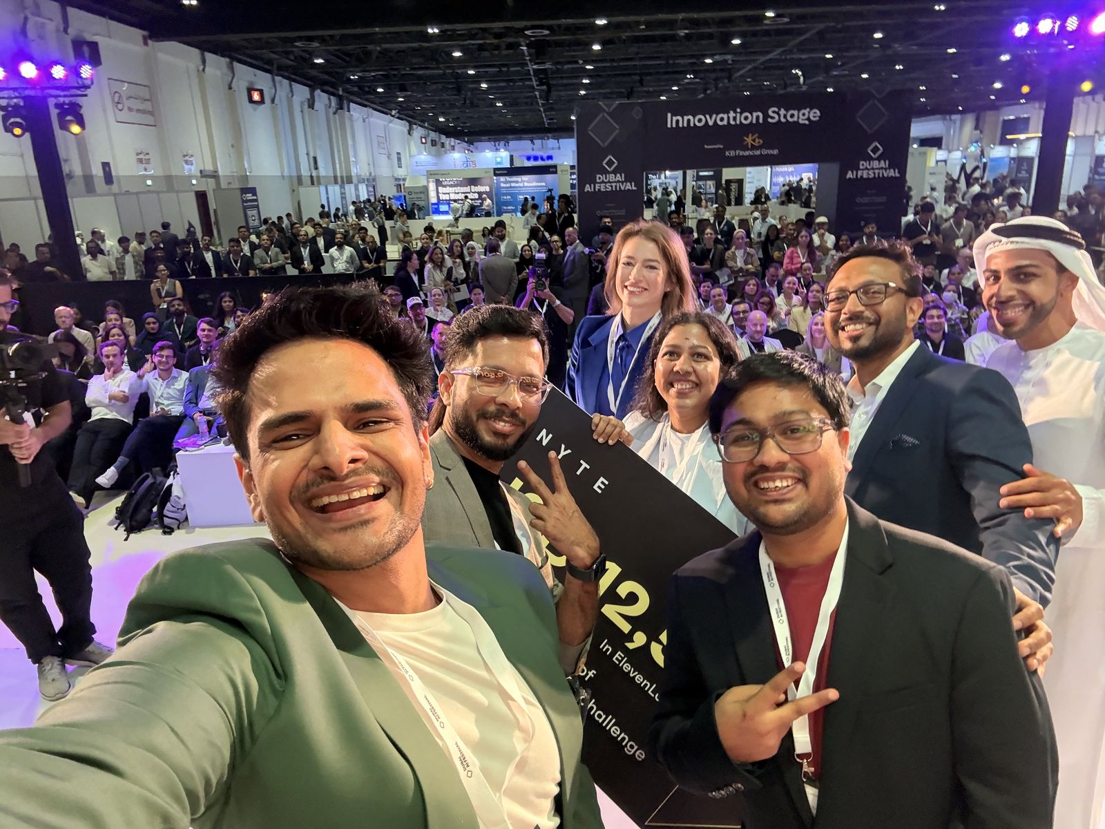 Narayan with Team Mizan holding the USD 12,500 winner's board, the Innovation Stage crowd behind them